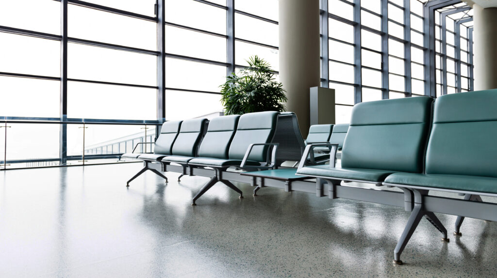 Airport departure waiting area with empty seats.